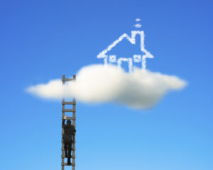 Businessman climbing on wooden ladder to reach cloud house