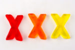 A set of three gummy letters in the shape of X isolated on white