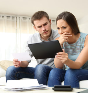 Worried couple checking credit account online
