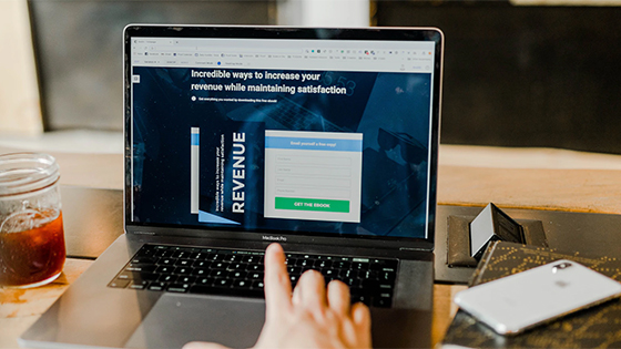 a hand pointing to a computer screen with a web page about revenue streams; image used for blog post about not-for-profit revenue sources