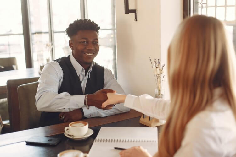 pexels-gustavo-fring-3874034 two people shaking hands while sitting down and having an interview