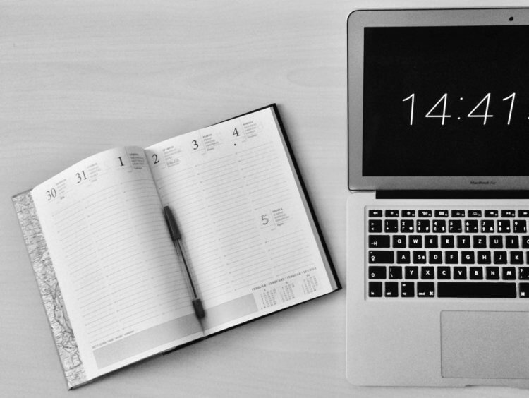 pexels-michaela-295826 A laptop displaying the time and a planner journal lays next to it