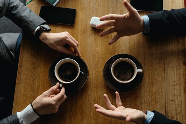 two people having a conversation over coffee